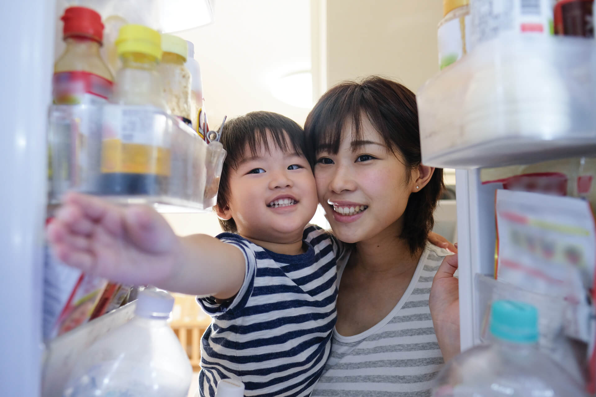 mom and toddler eating veggie smiling