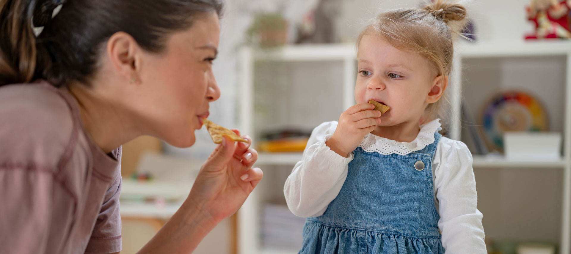 Mother and daughter eating chips together