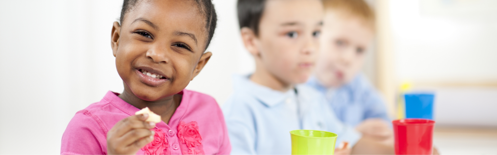 Child smiling and eating at a colorful table