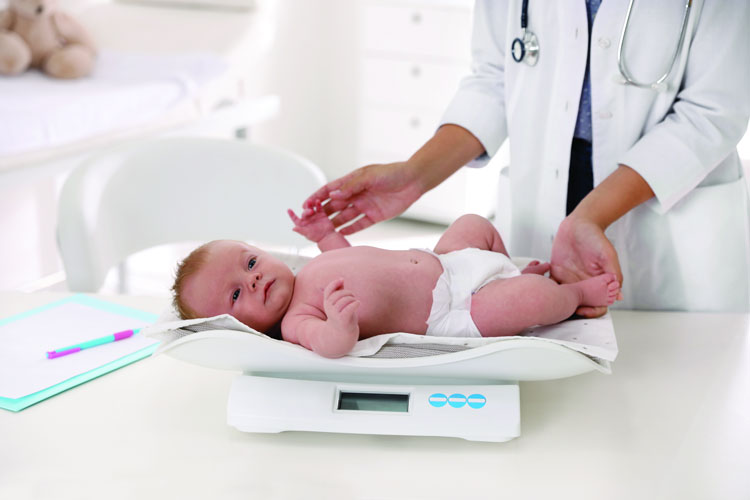 Dr weighing baby